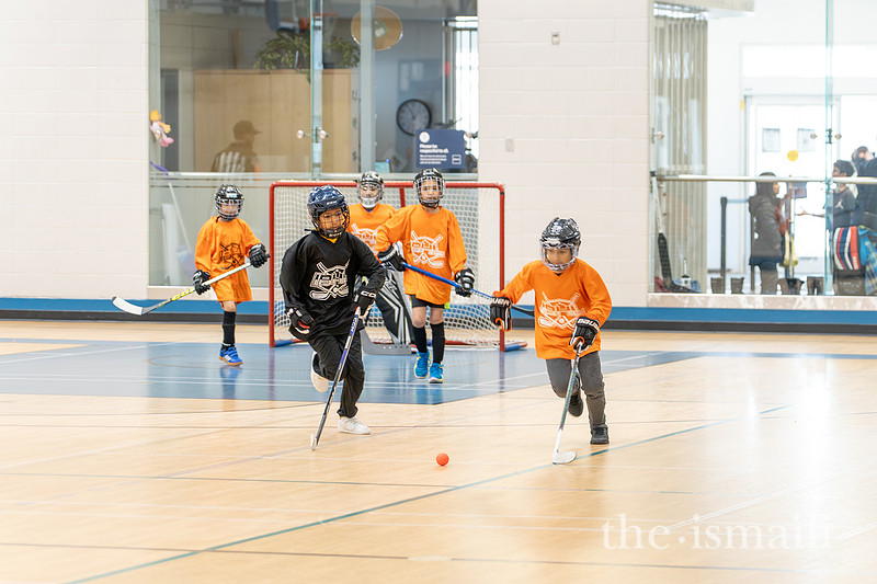 IBHL players in orange and black chasing the ball